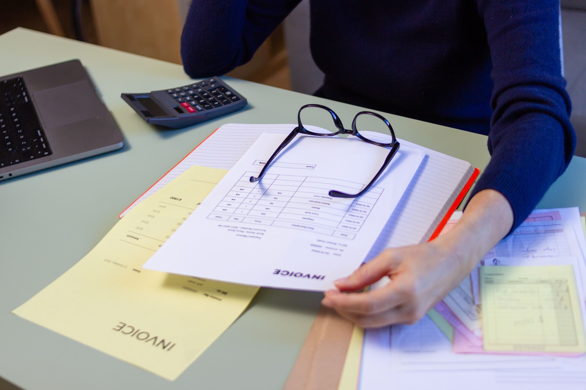 Accountant reviewing invoices and financial documents at office desk